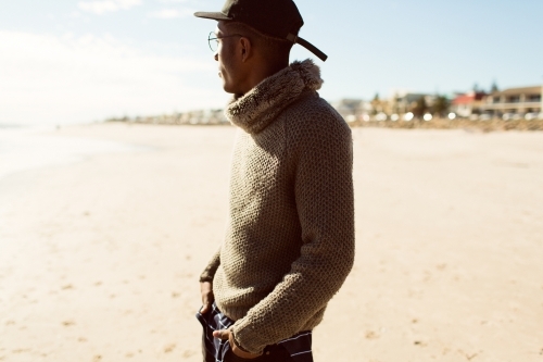 Young man standing on the beach looking away - Australian Stock Image