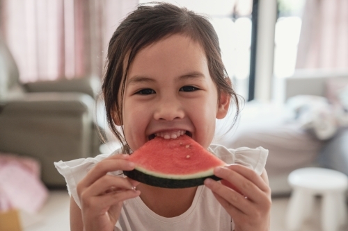 Young multicultural girl having watermelon in summer - Australian Stock Image