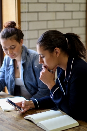 Young people sitting at a desk in a classroom - Australian Stock Image