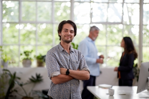 Young professional man standing in an open plan office - Australian Stock Image