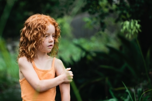 Young redhead girl in an orange singlet - Australian Stock Image