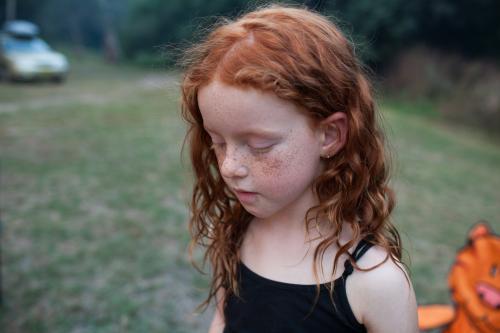 Young redhead girl looking down - Australian Stock Image