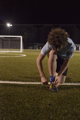 Young teen boy preparing to do evening soccer training - Australian Stock Image