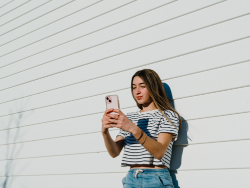 Young teenage girl holding a mobile device. - Australian Stock Image