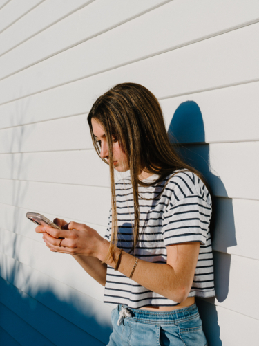 Young teenage girl holding a mobile device. - Australian Stock Image