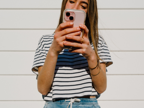 Young teenage girl holding a mobile device. - Australian Stock Image