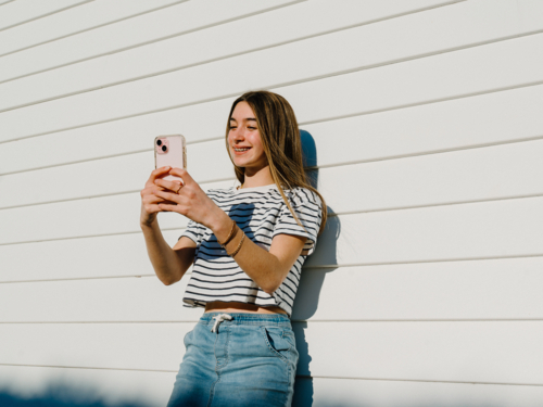 Young teenage girl taking selfies with her mobile device. - Australian Stock Image