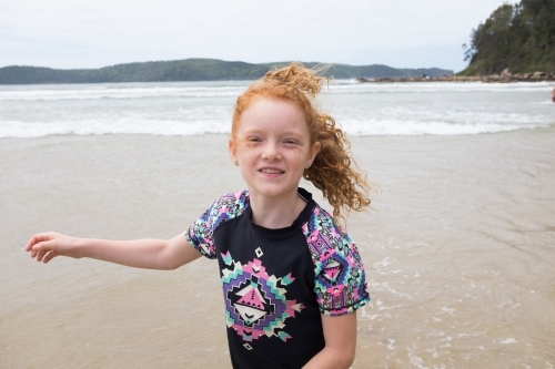 Young windswept girl smiling at the beach - Australian Stock Image