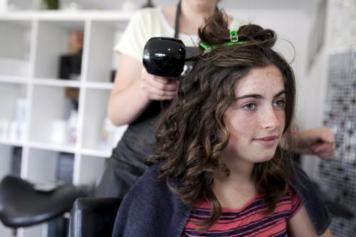 Young woman at hairdressers having hair styled - Australian Stock Image