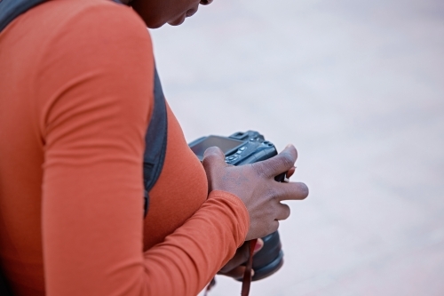 Young woman checking back of digital camera - Australian Stock Image