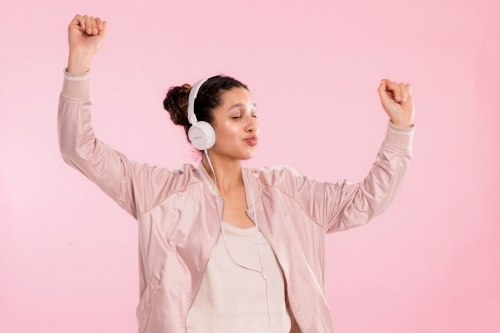 young woman, listening to music on headphones & dancing. - Australian Stock Image