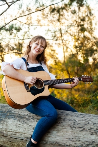 Young woman sitting on long playing instrument - Australian Stock Image