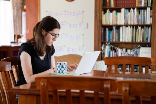 Young woman studying from home on laptop computer - Australian Stock Image