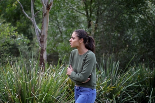 Young woman walking alone in outdoor setting - Australian Stock Image