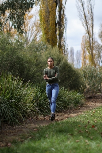 Young woman walking alone in the park - Australian Stock Image